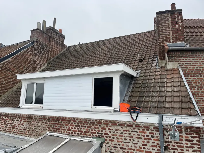 Lucarne aux planches de rive repeintes en blanc, après travaux
