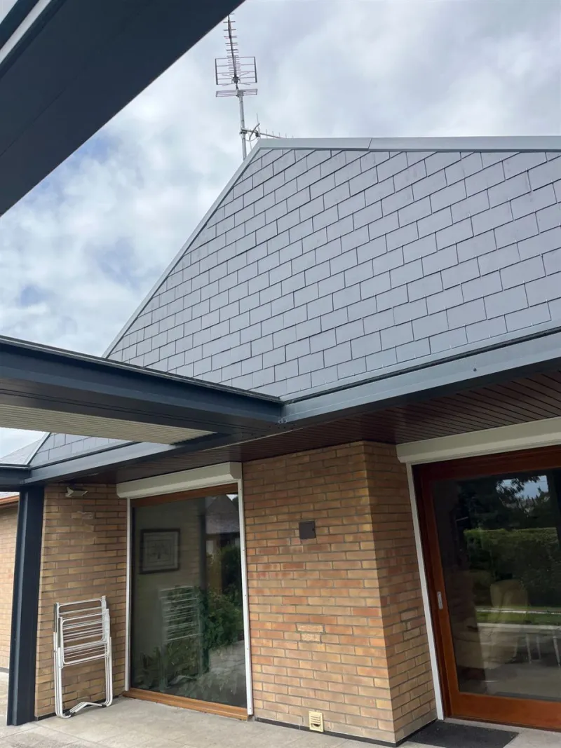 Pignon habillé d'ardoises au-dessus d'une terrasse, rives anthracite