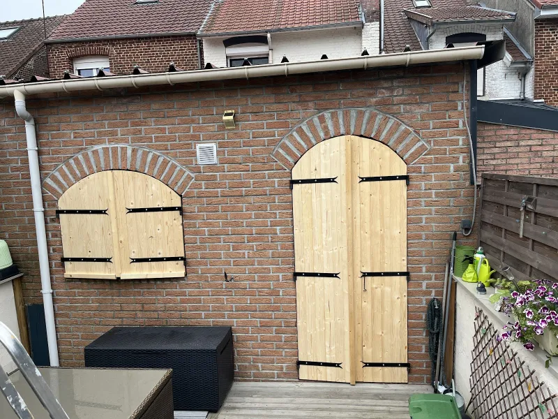 Volets et porte cintrés en bois brut, avant mise en peinture